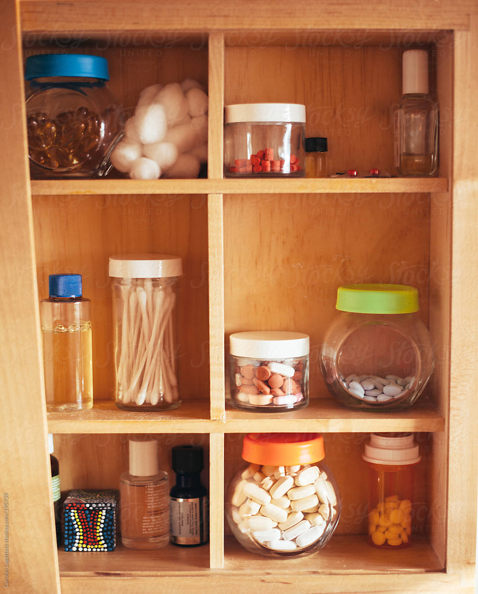 Medicine cabinet filled with vitamins, medication, oils and other bathroom items
