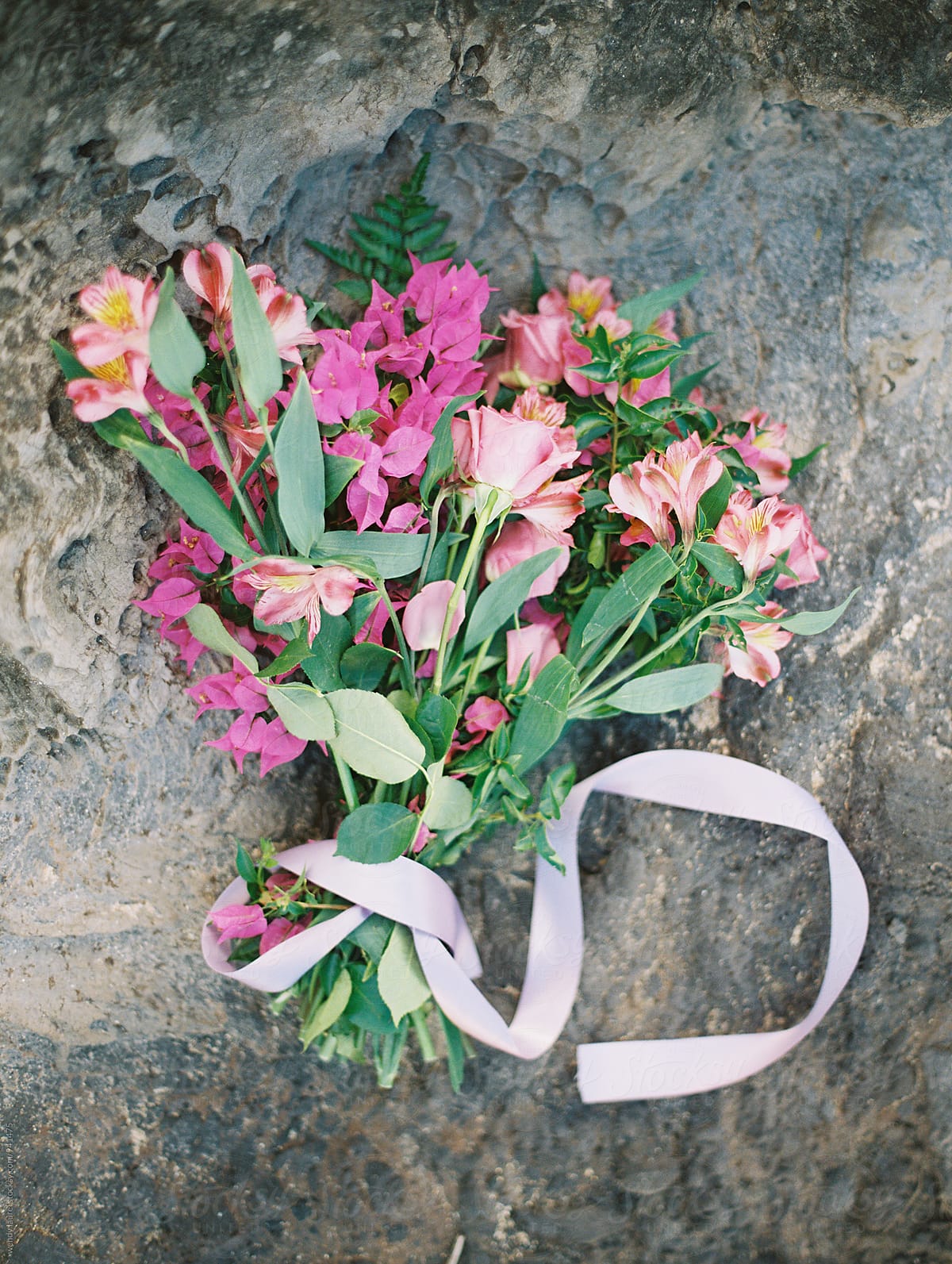 pink bridal bouquet on grey ocean rock