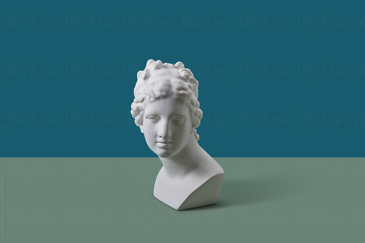 White Aphrodite bust on blue and green background.