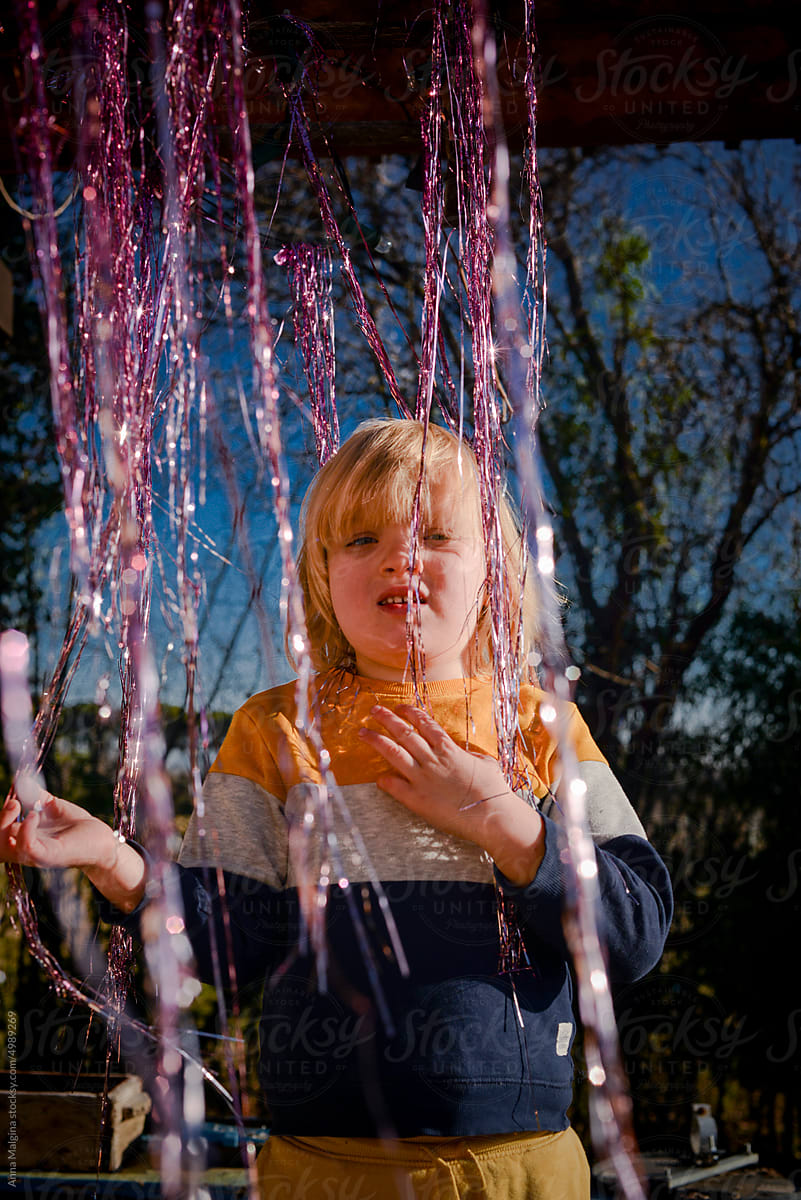 A kid in a A Shiny pink Foil Fringe Curtain