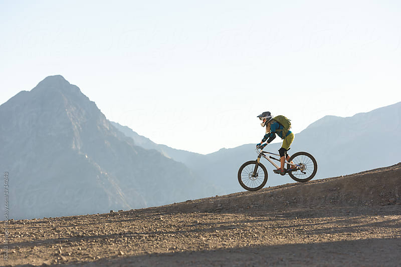 Woman riding mountain bike donwhill backcountry route
