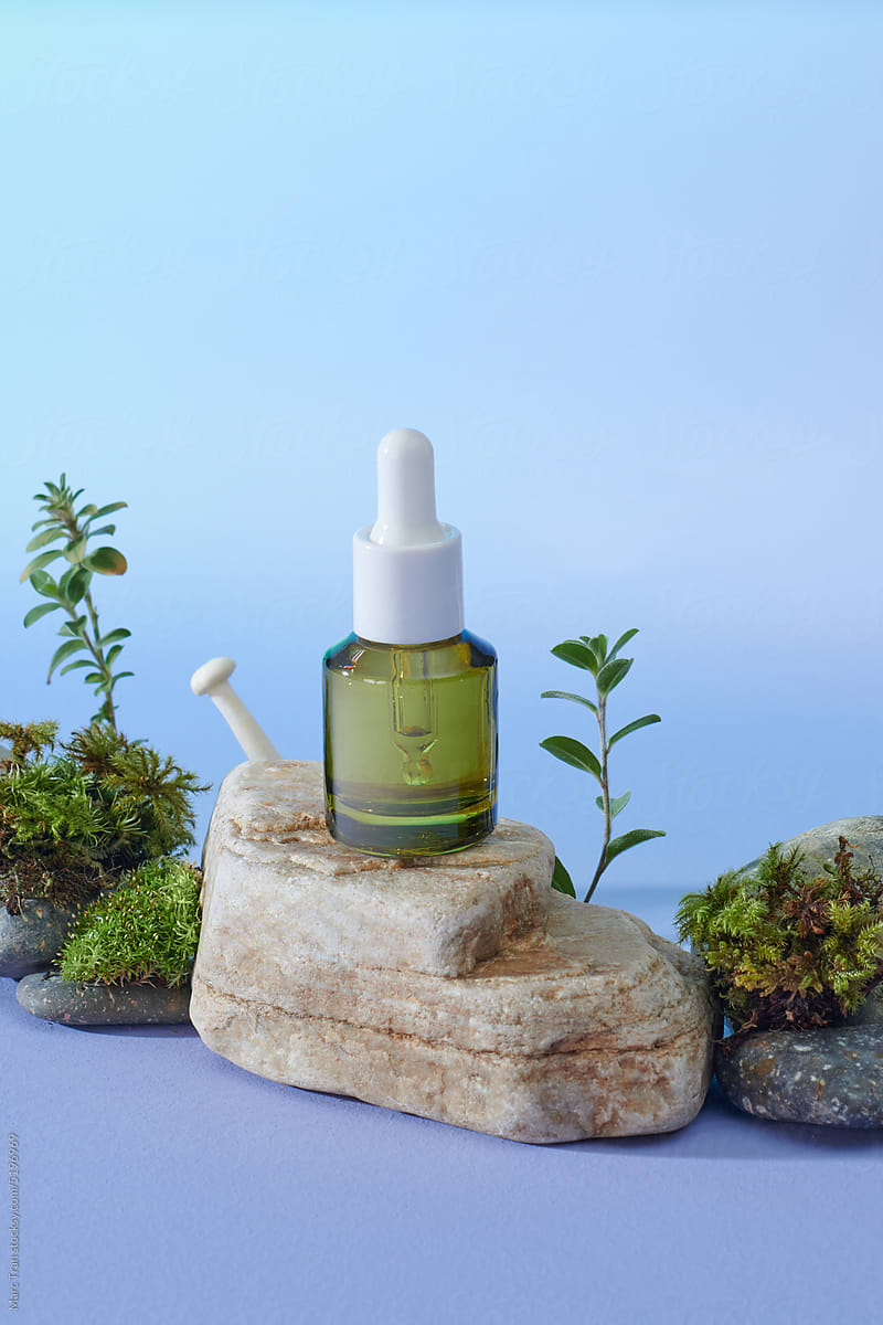 Glass bottle with cosmetic essential oil and natural stone stand