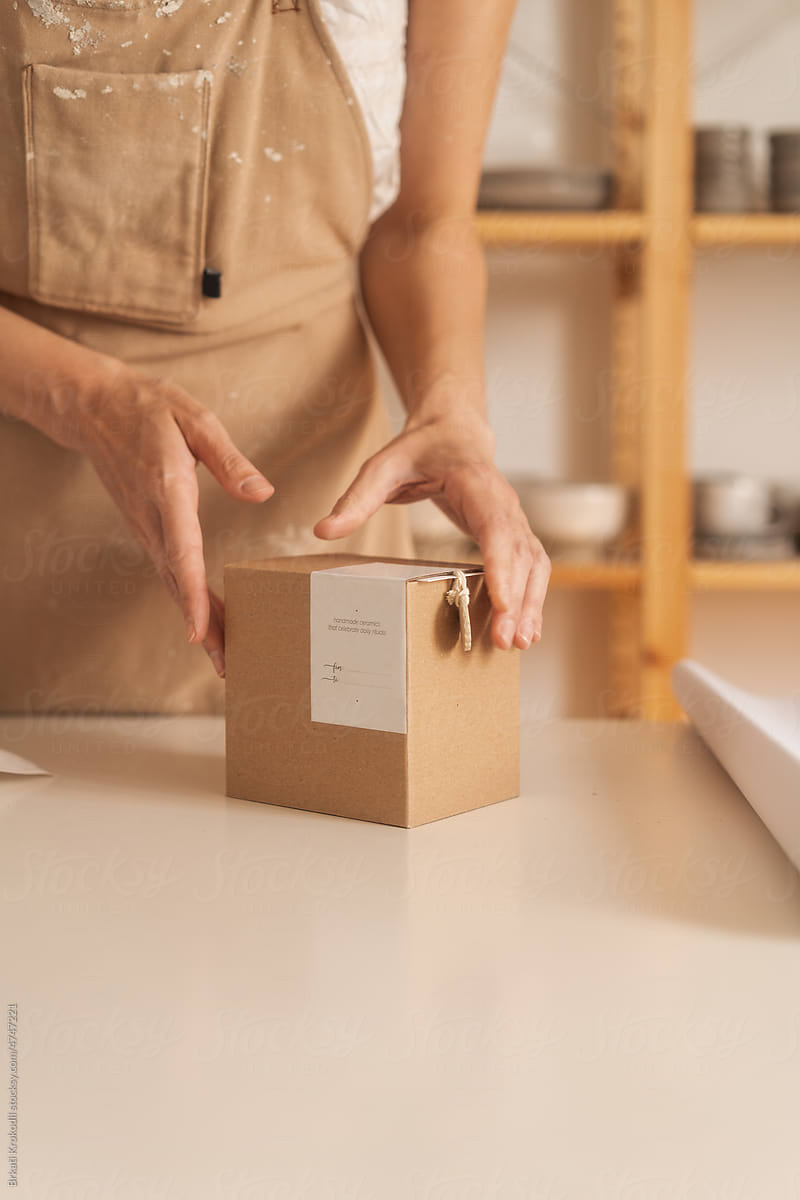 Anonymous Artisan Packing A Product In A Cardboard Gift Box