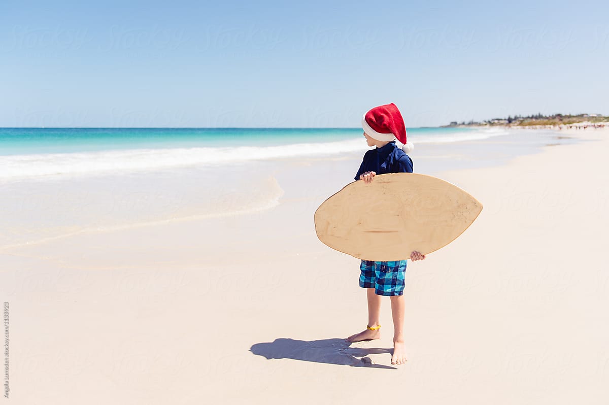 Child with a skim board at the beach: Christmas in Australia