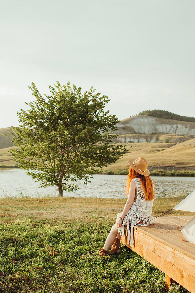 Anonymous woman admiring river in countryside