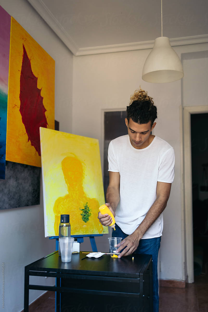 Young artist preparing his materials to paint a picture on canvas