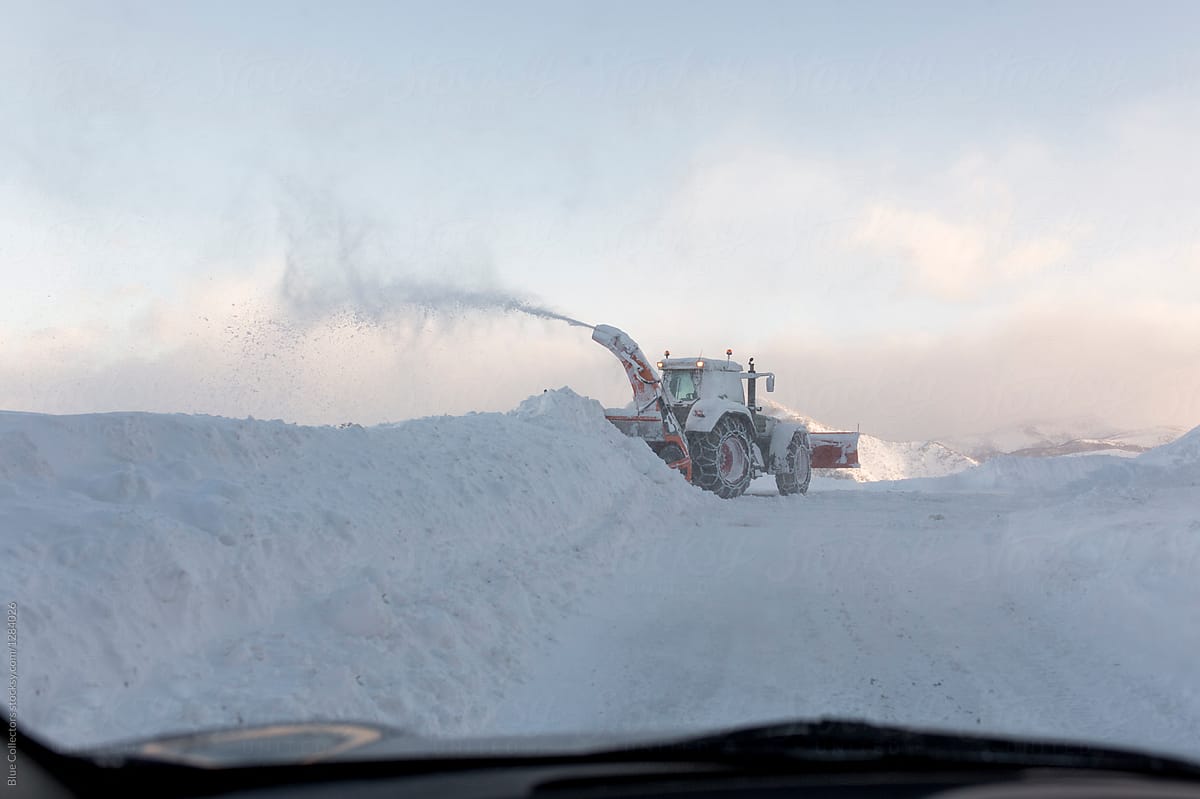 view from the car of a machine that cleaning the road from snow