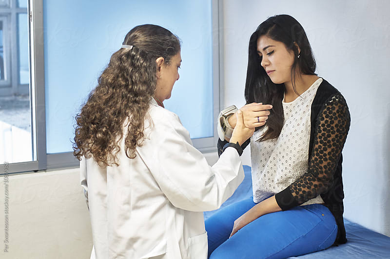 Female doctor examining young female patient
