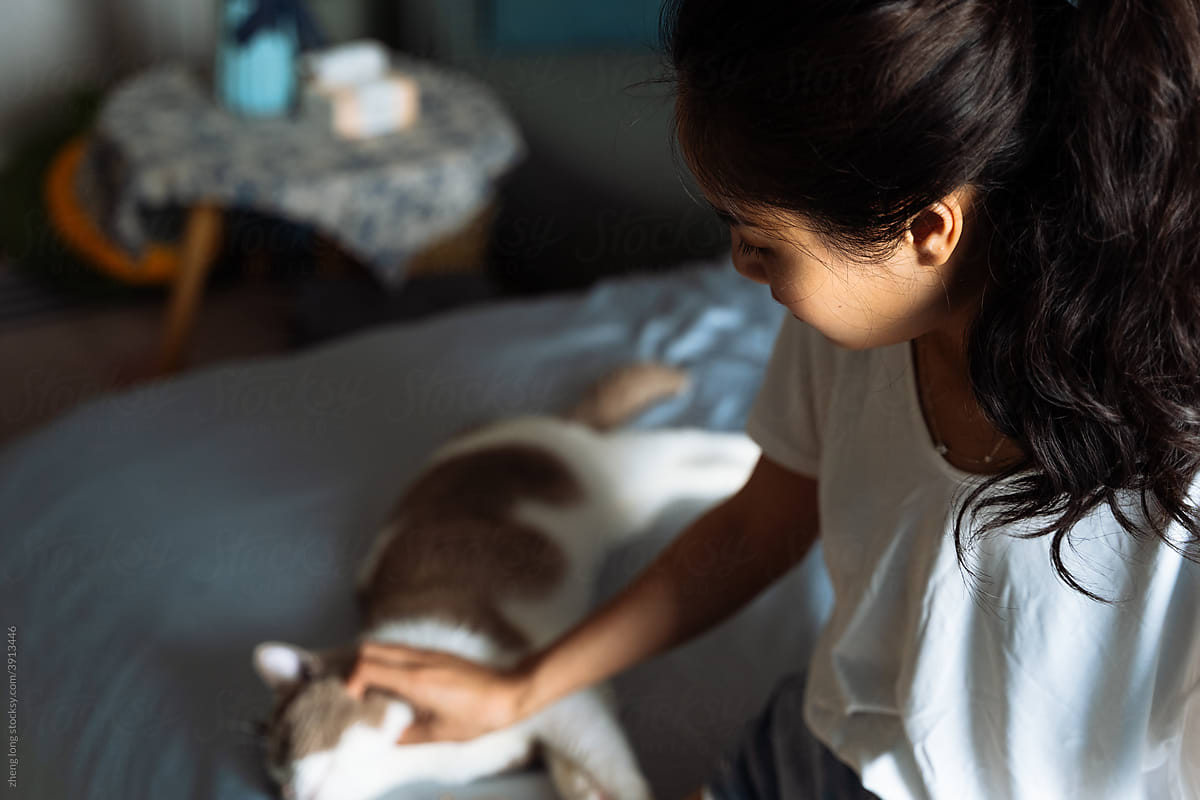 young girl playing with cat