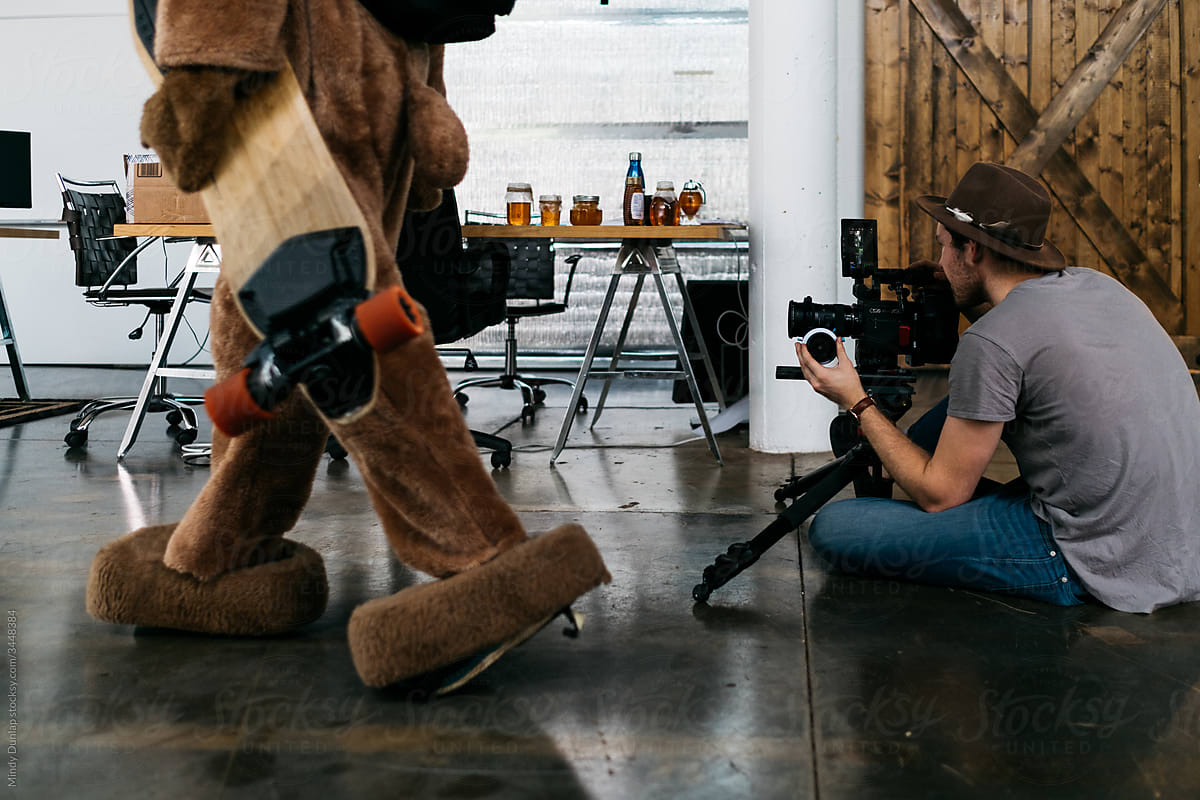A cinematographer films a man in a bear costume