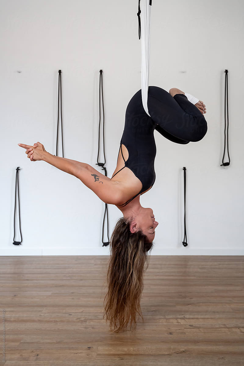 Young Woman Upside Down Doing Aerial Yoga