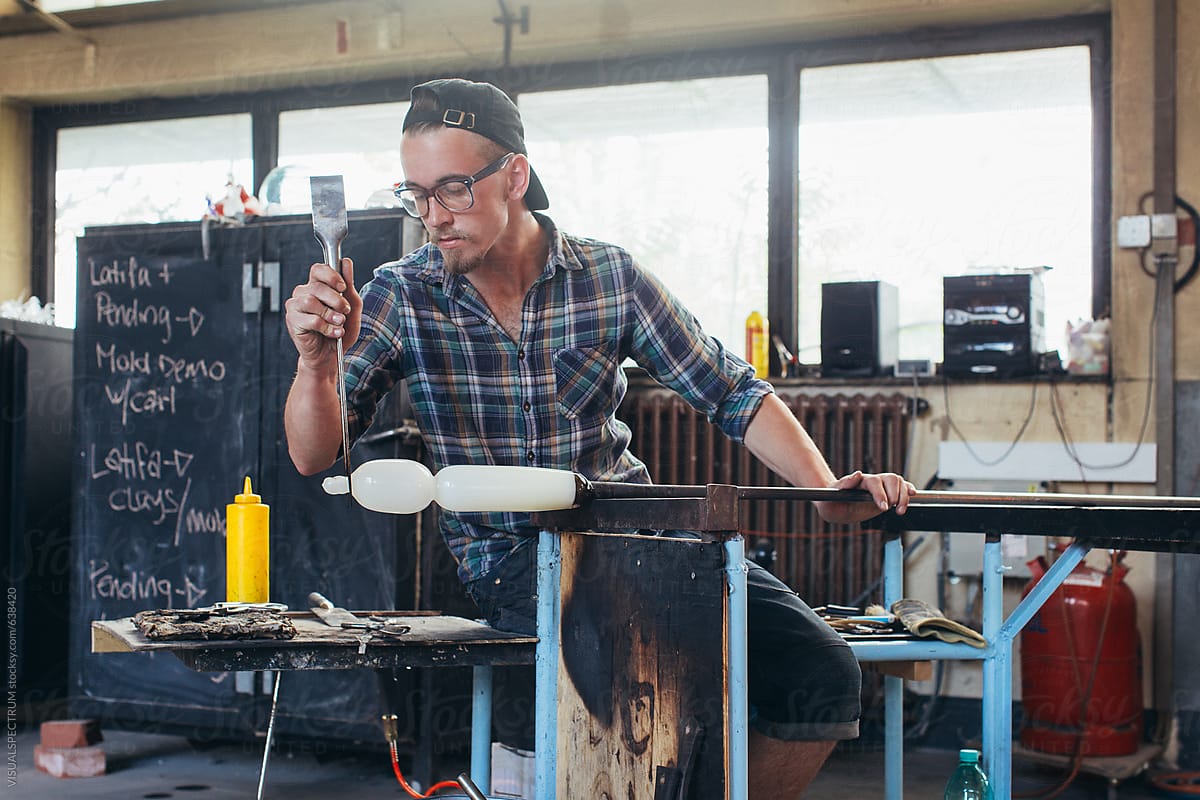 Artisan Glass Workshop - Young Male Hipster Artist Shaping Hot Glass With Jacks