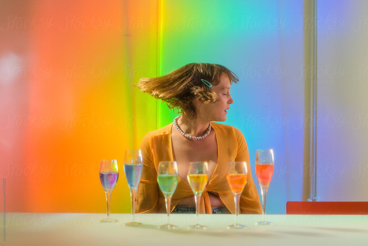 Woman Poses in Rainbow Room with Pride Themed Glasses