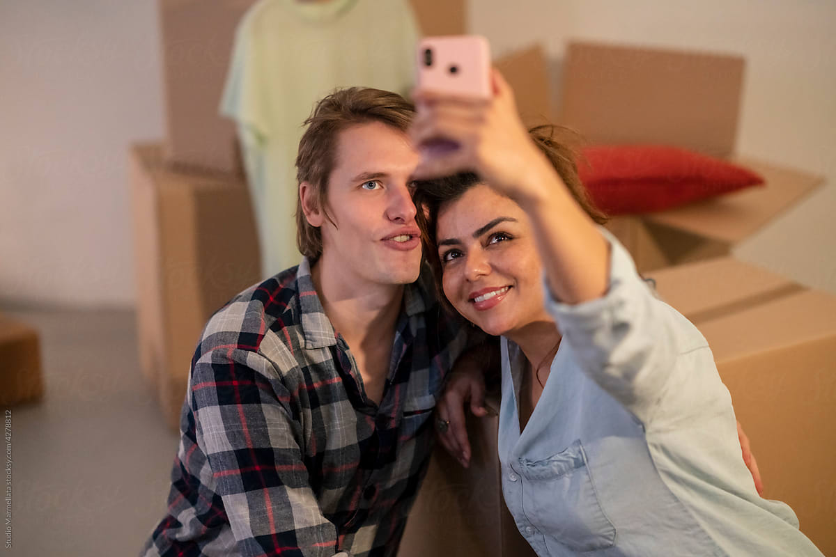 Happy couple taking selfie after relocation