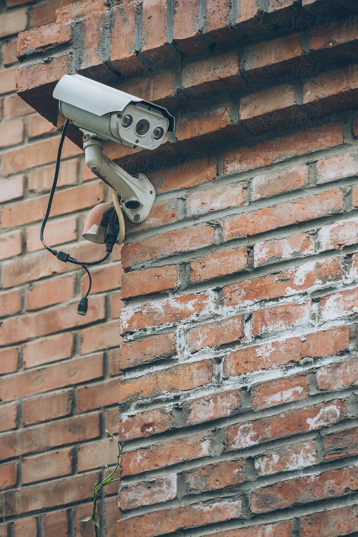 Security camera on red brick wall
