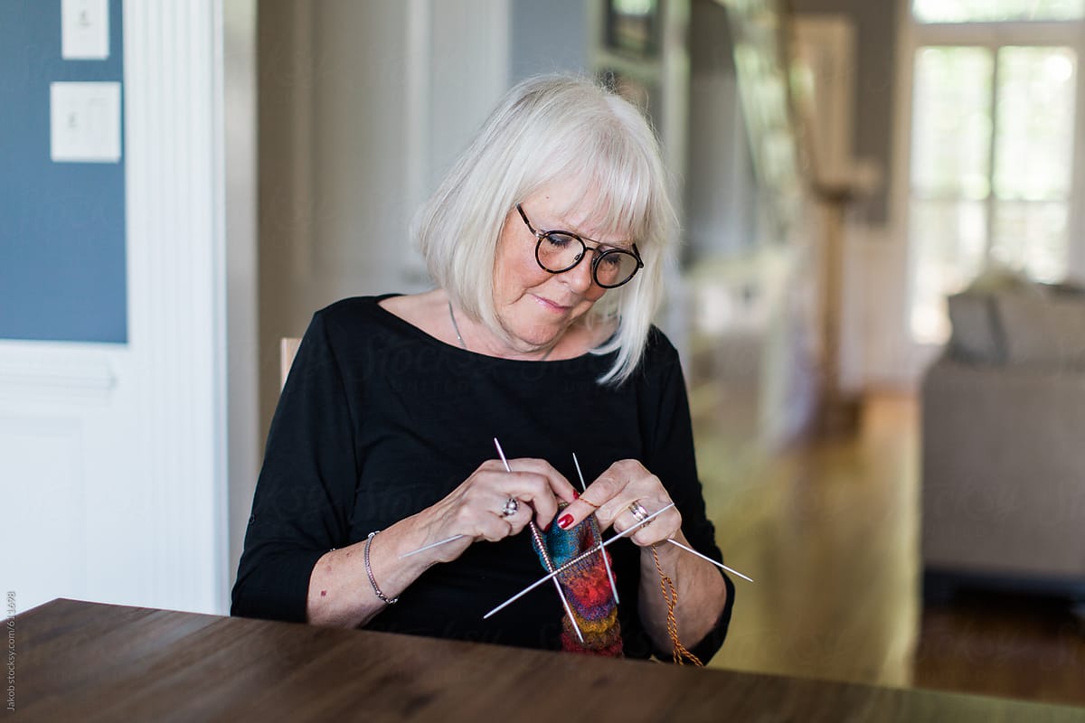 Senior woman knitting by a table