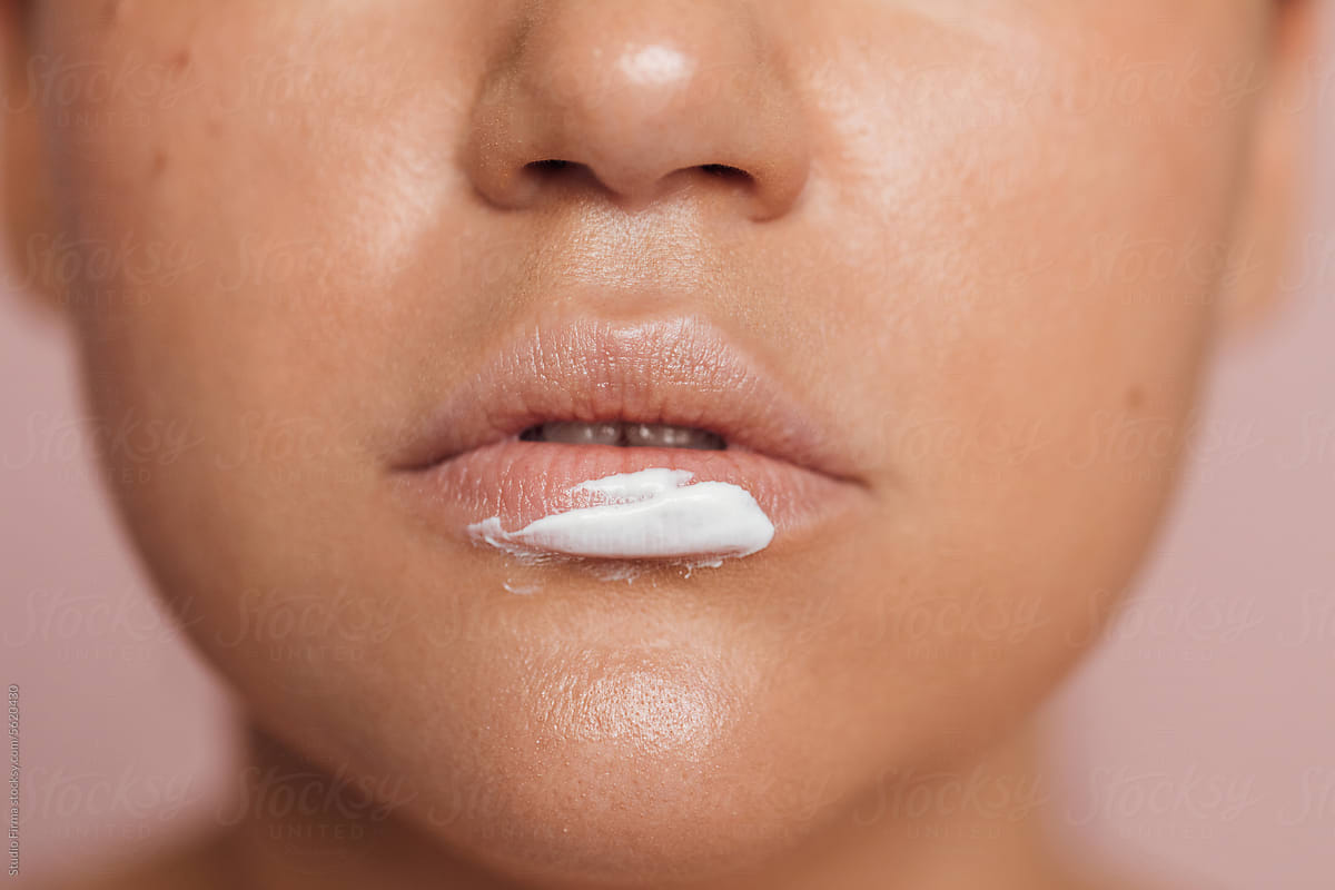 Woman\'s lip covered with facial cream