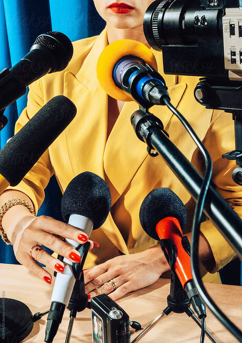 Female Speaker talking to microphones in studio .
