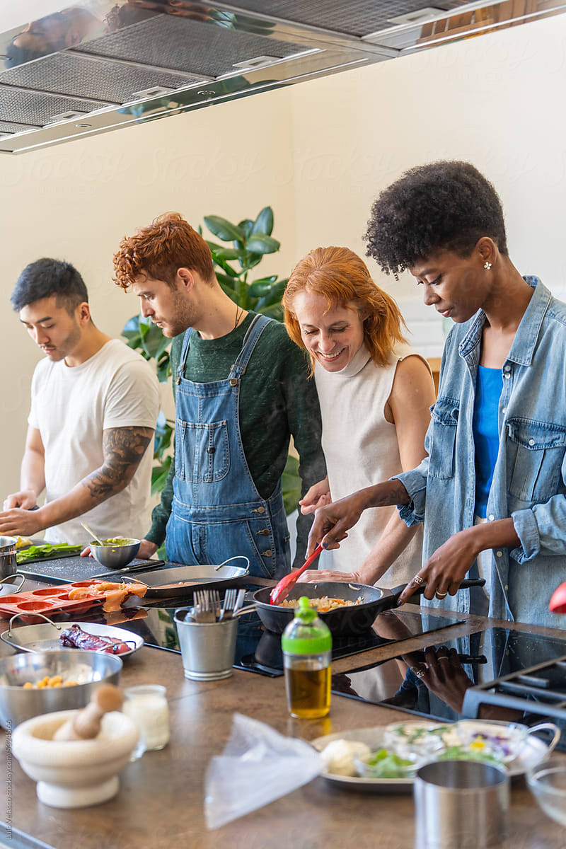 Multiracial Group Of Friends Cooking A Meal Together.
