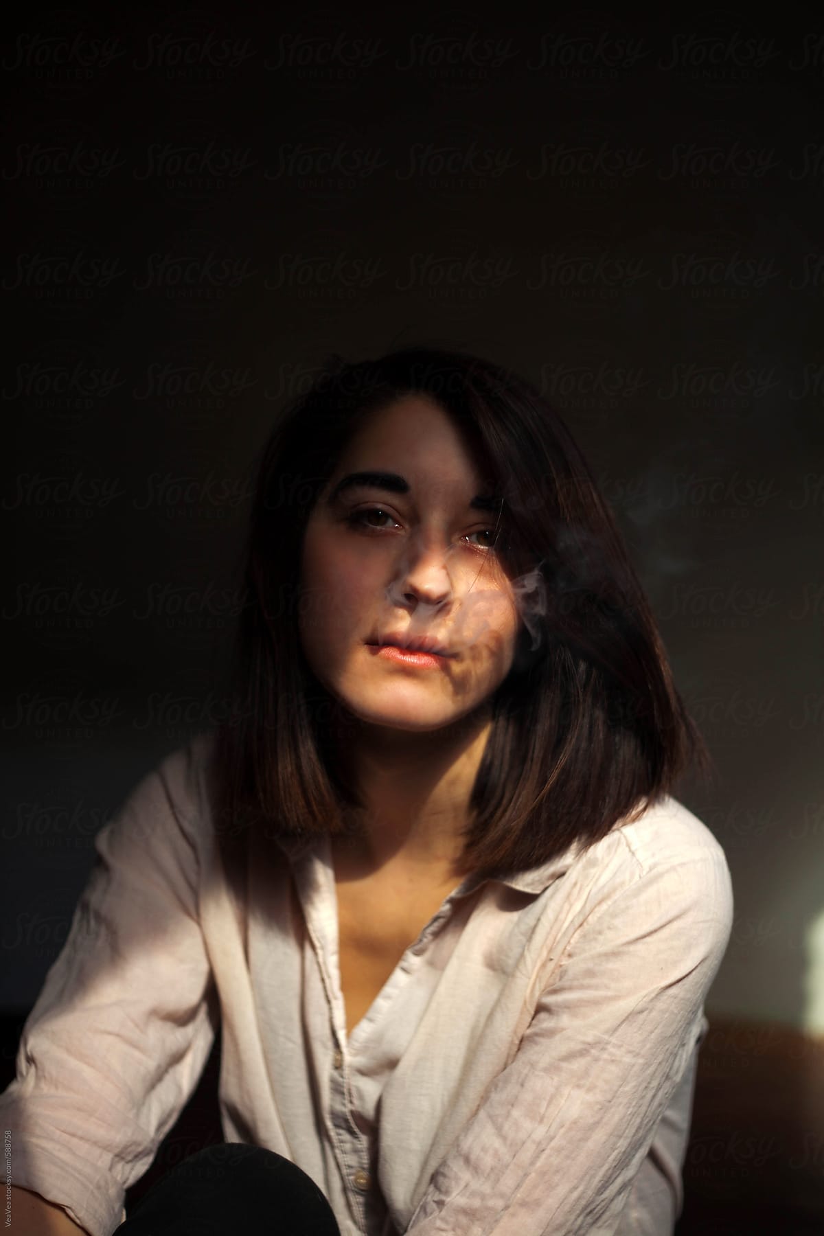 Portrait Of A Young Woman Blowing Smoke On A Light By Vertikala 