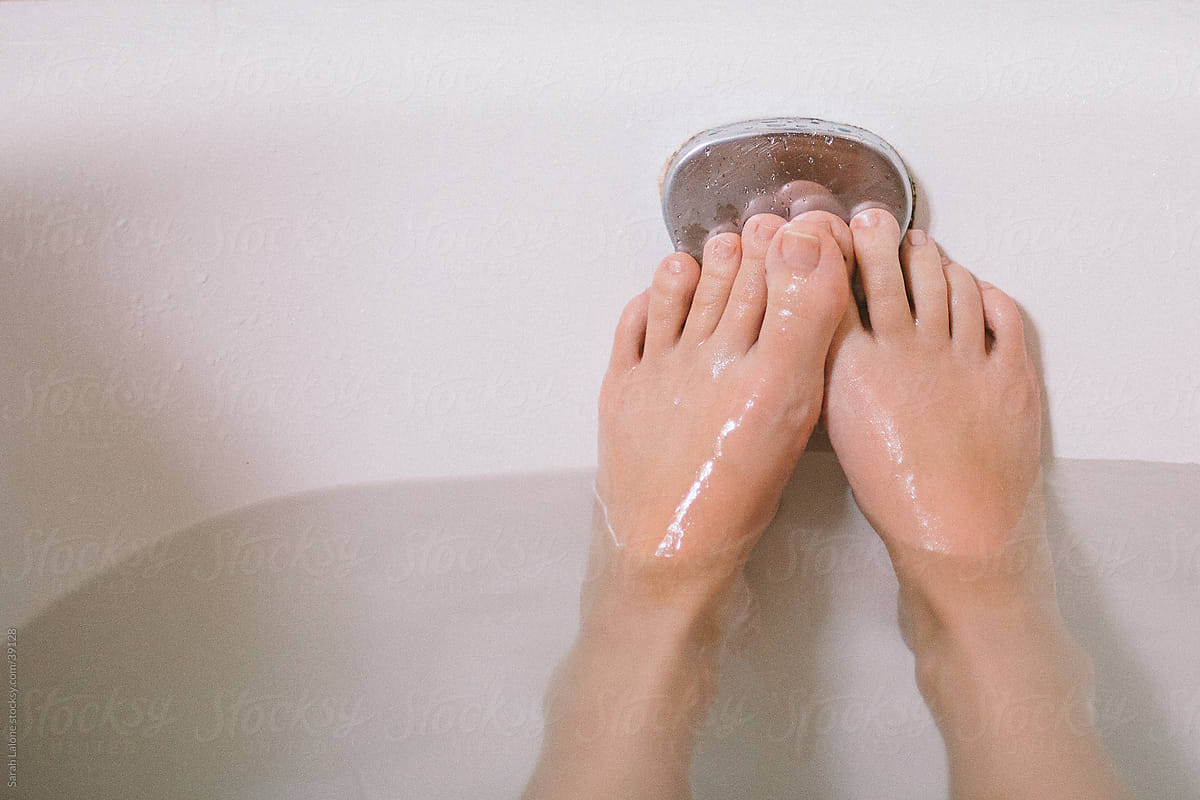 A woman\'s feet in the bathtub.