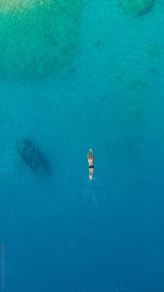 young athletic man diving in turquoise water
