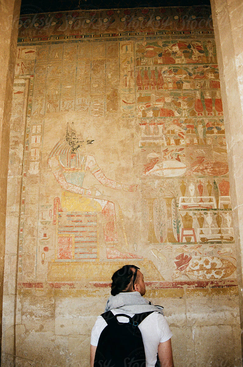Tourist Exploring Ancient Egyptian Temple Hieroglyphs