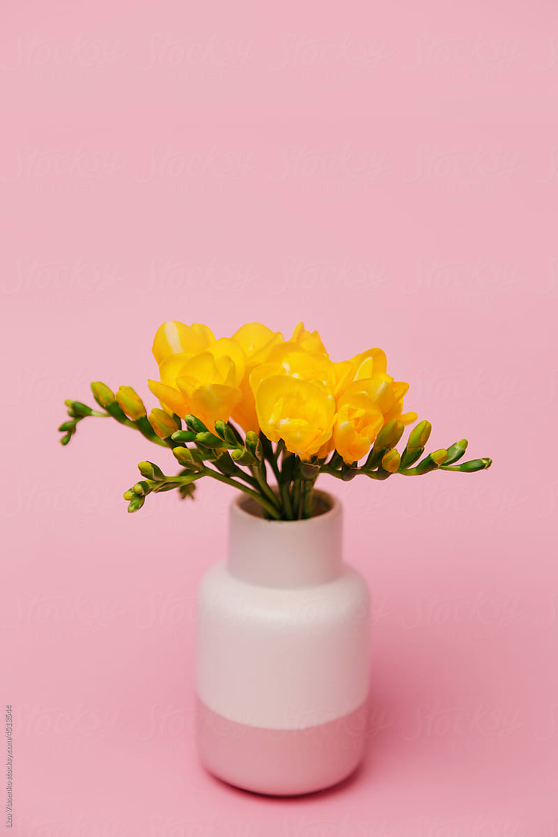Pink vase with yellow flowers