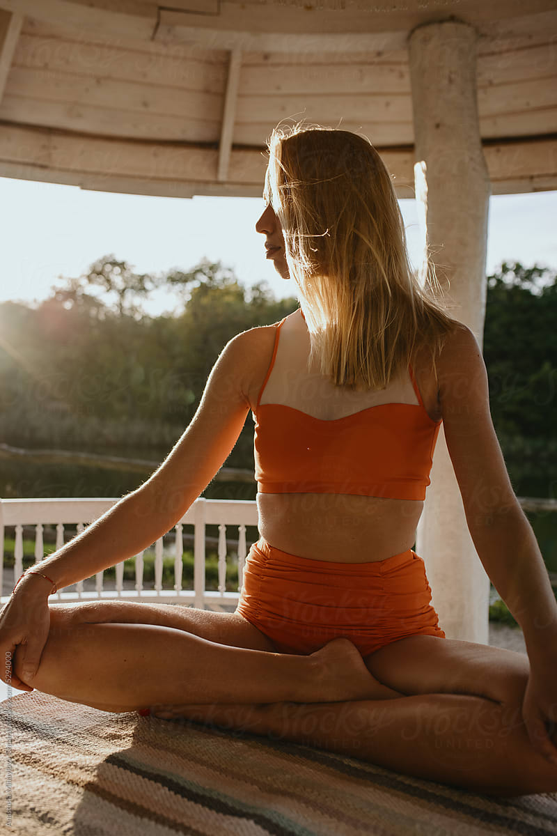 Blonde Woman doing yoga outside in the summer on the sunset