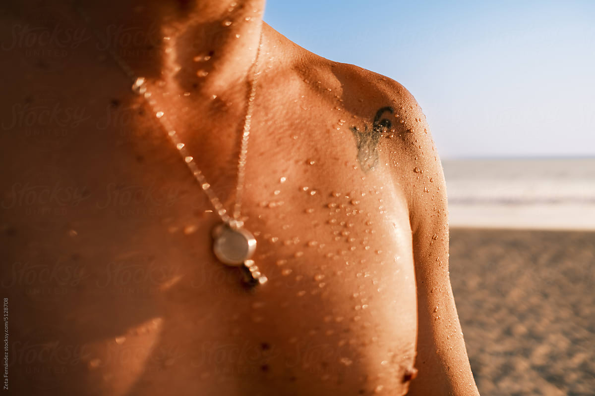 naked torso with water droplets at sunset time