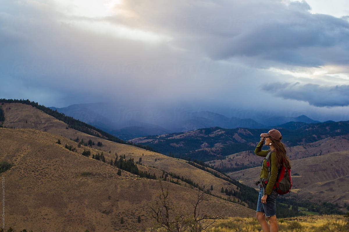 Woman stands looking out into the mountainous landscape of the Methow Valley in Washington State