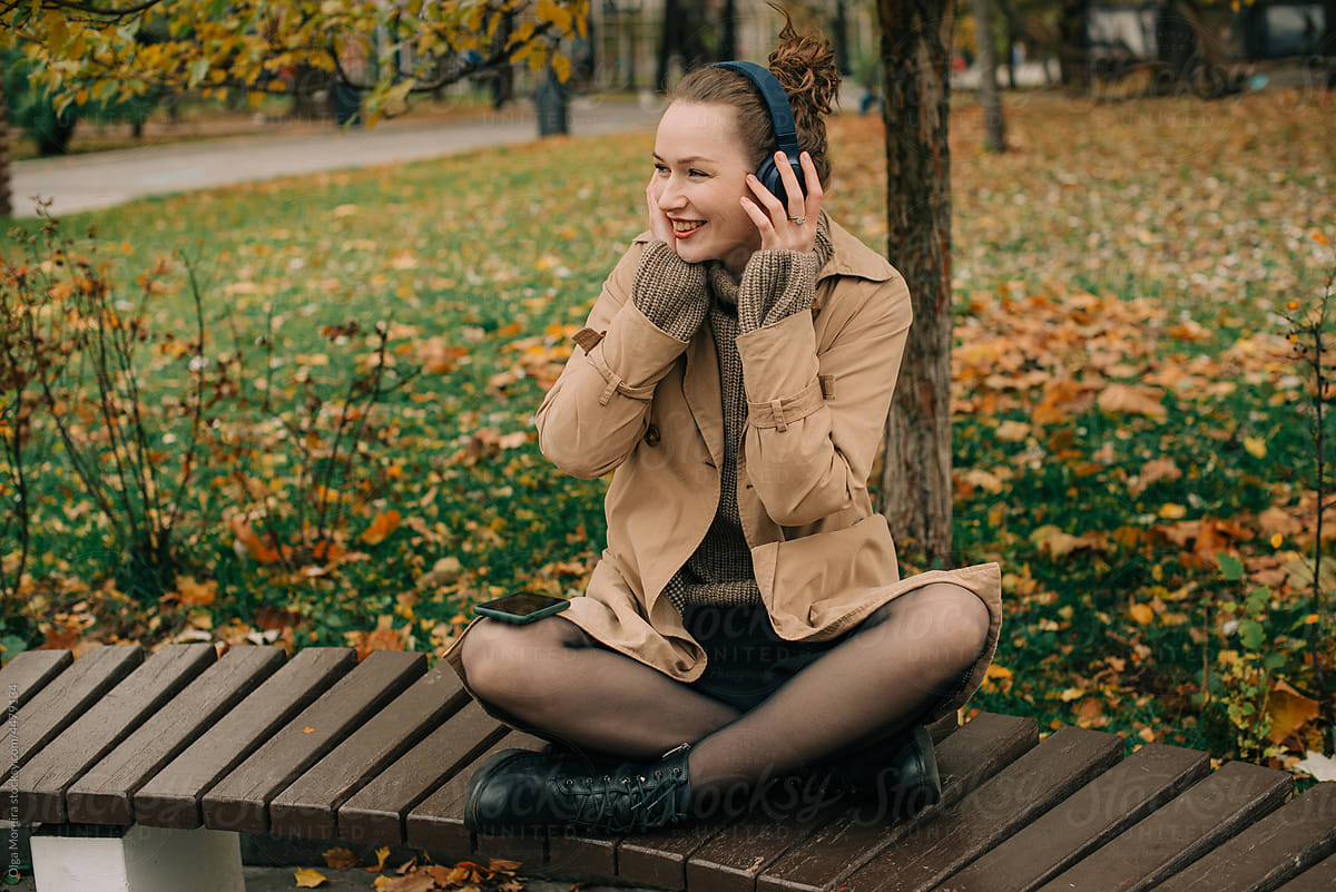 Woman enjoying happy music in autumn park