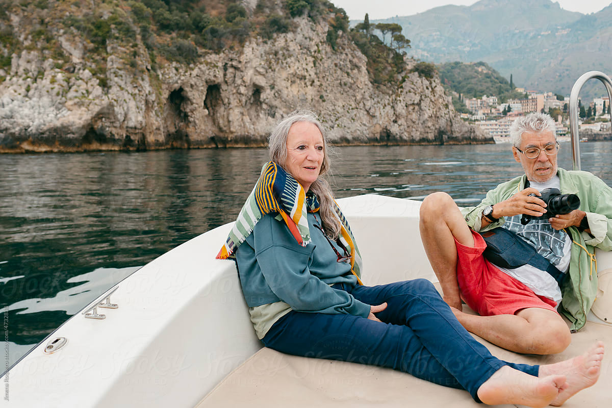 Senior couple in expedition on motorboat sailing the Sicilian coast