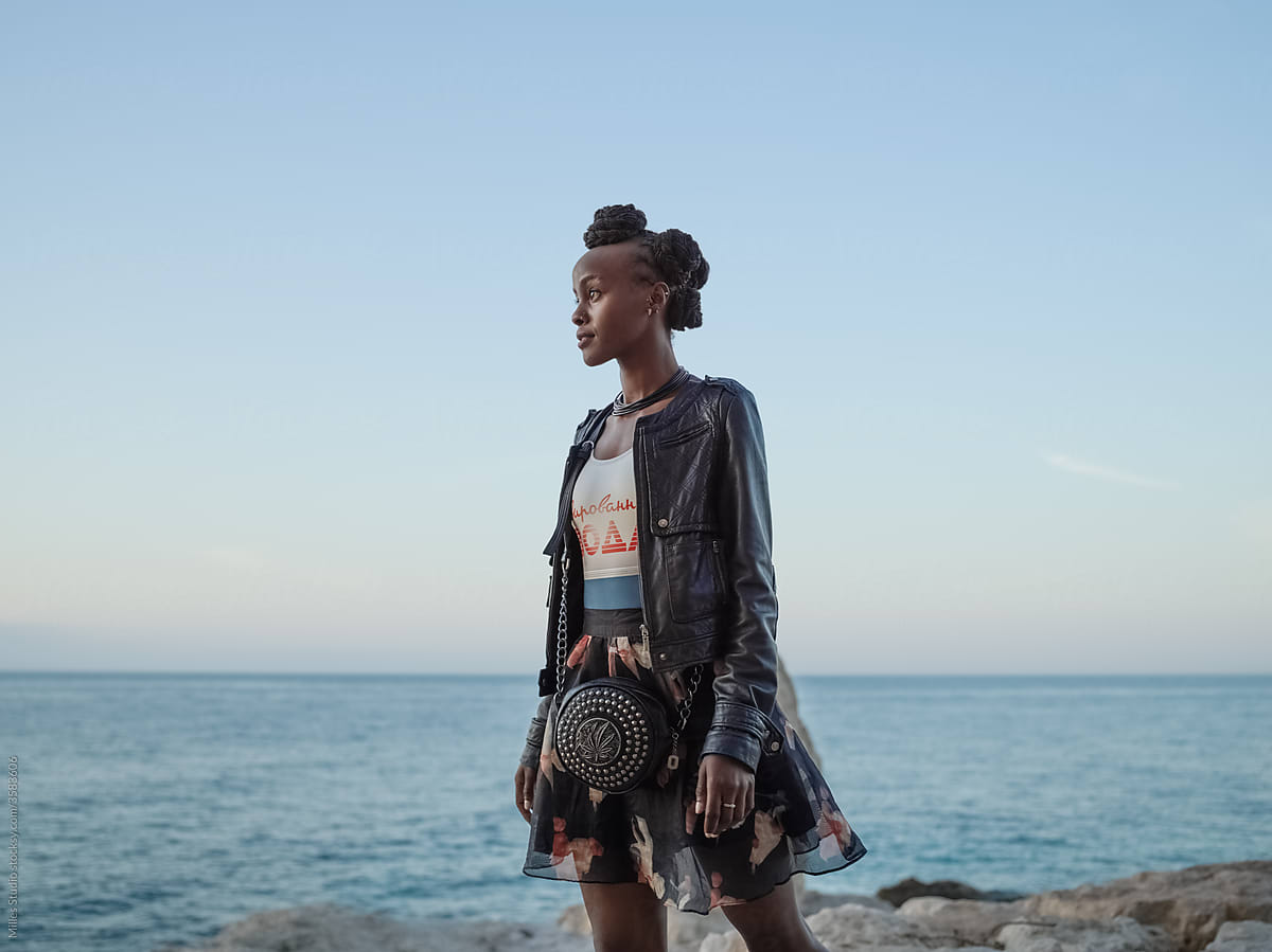 Stylish black woman spending time on seashore