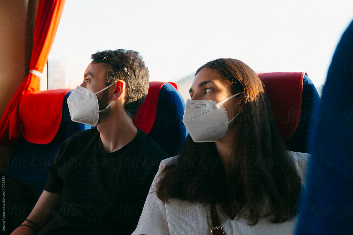 Young Couple traveling on intercity bus wearing face-mask