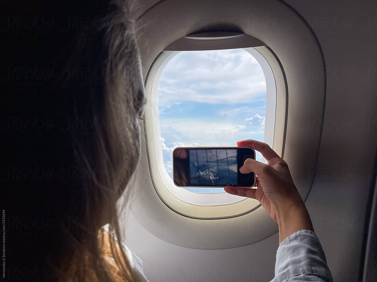Woman Using Phone While Flying By Plane