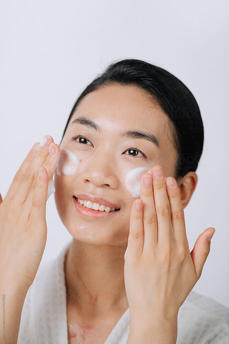 Portrait of cute smiling woman with foaming cleanser.