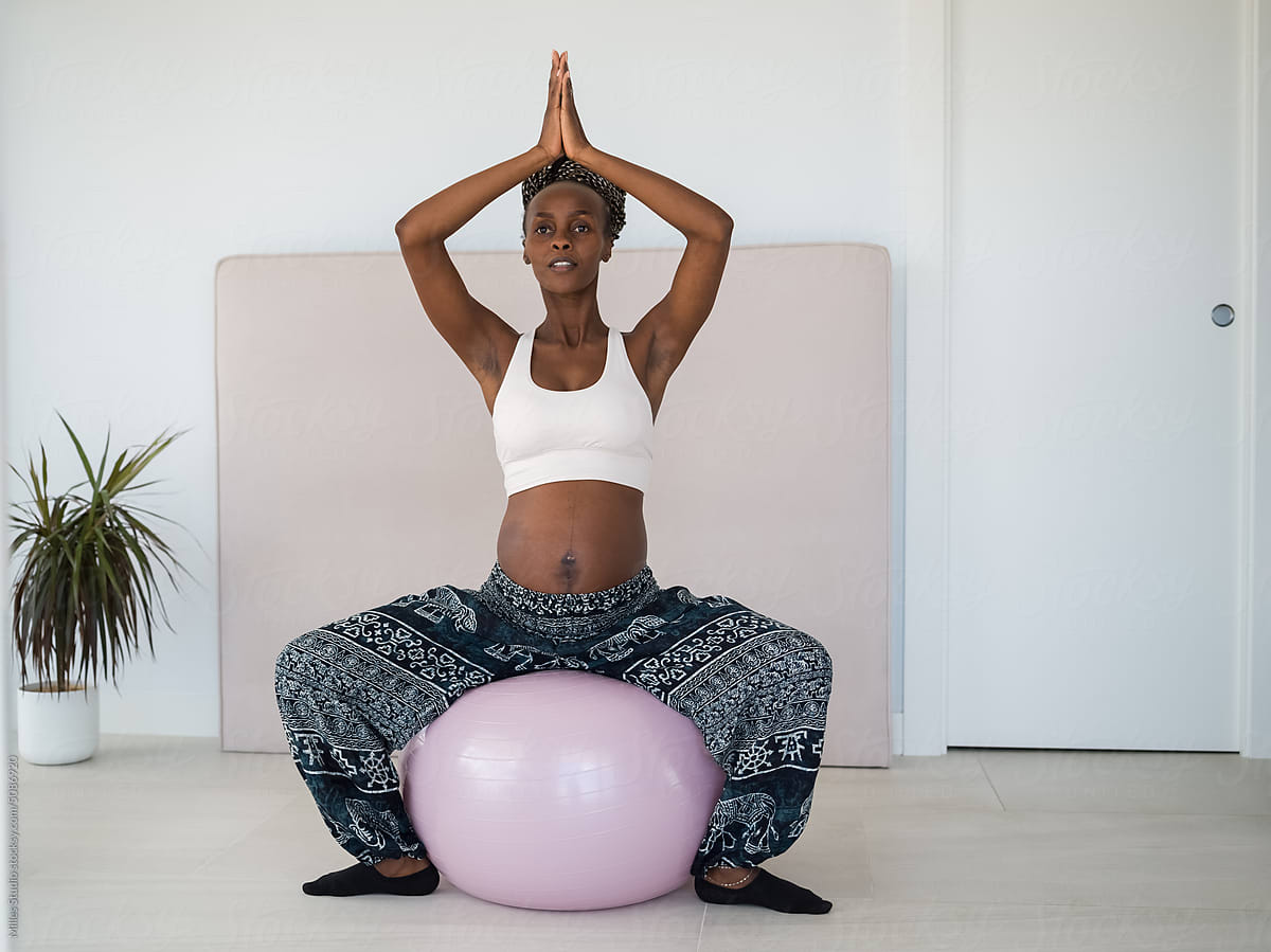 Black woman expecting baby sitting on fit ball