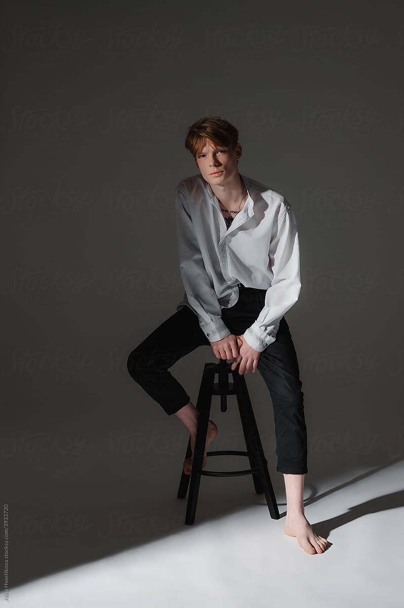 Barefoot young man on stool