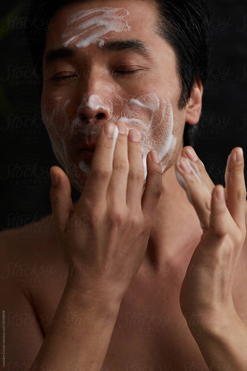 Guy washing his face
