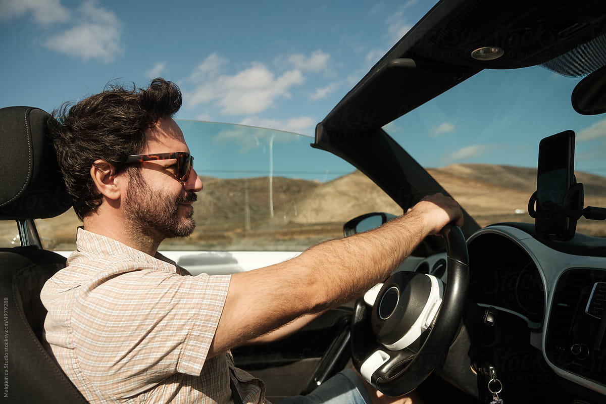 Young Man With Sunglasses Driving A Convertible Car by Stocksy Contributor  Inuk Studio - Stocksy