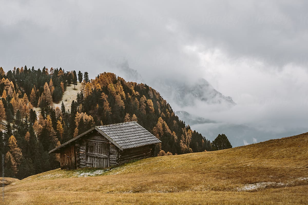 wooden mountain hut in foggy autumnal mountain landscape