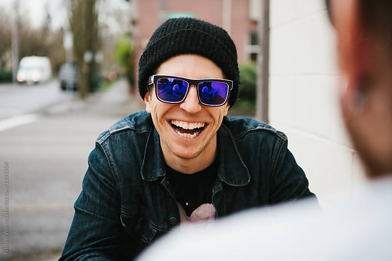 Man Wearing Sunglasses laughing with a Friend