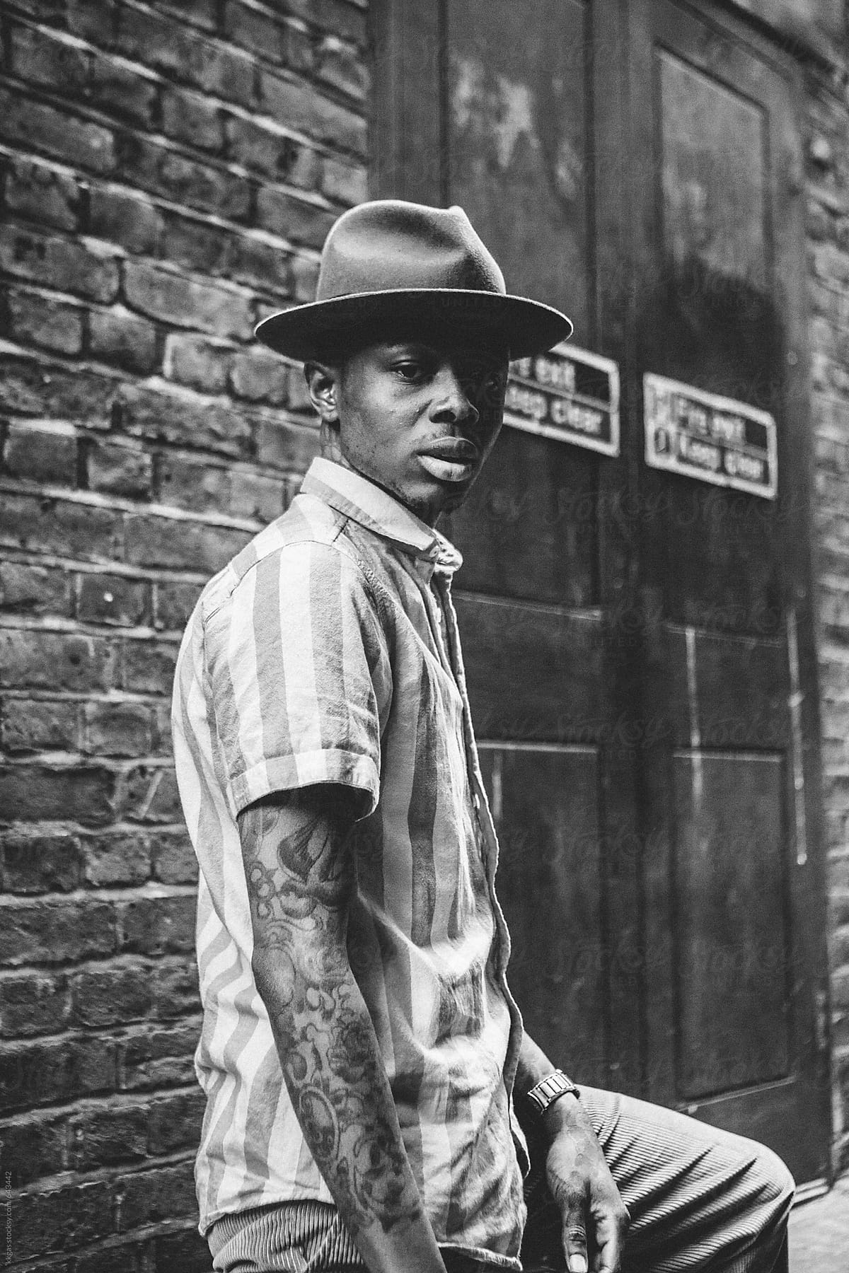 Stylish young black man with tattoos in an urban setting