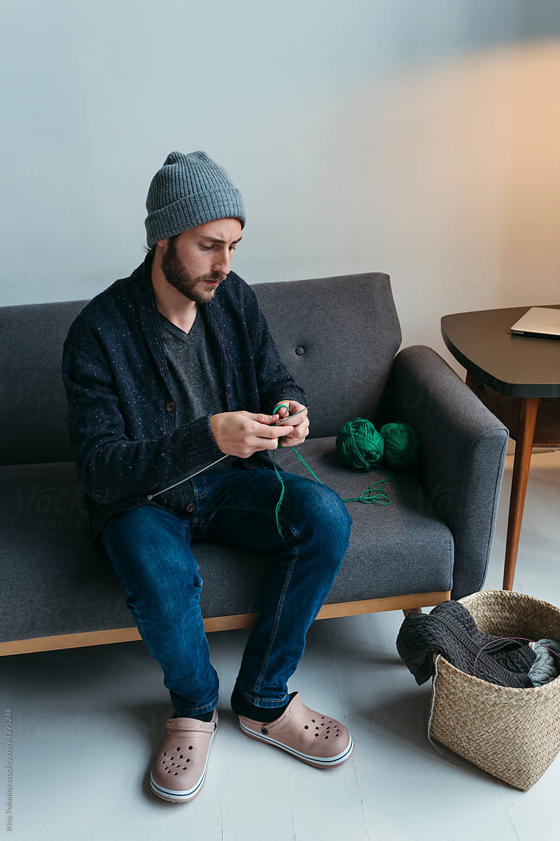 Man knitting at home.