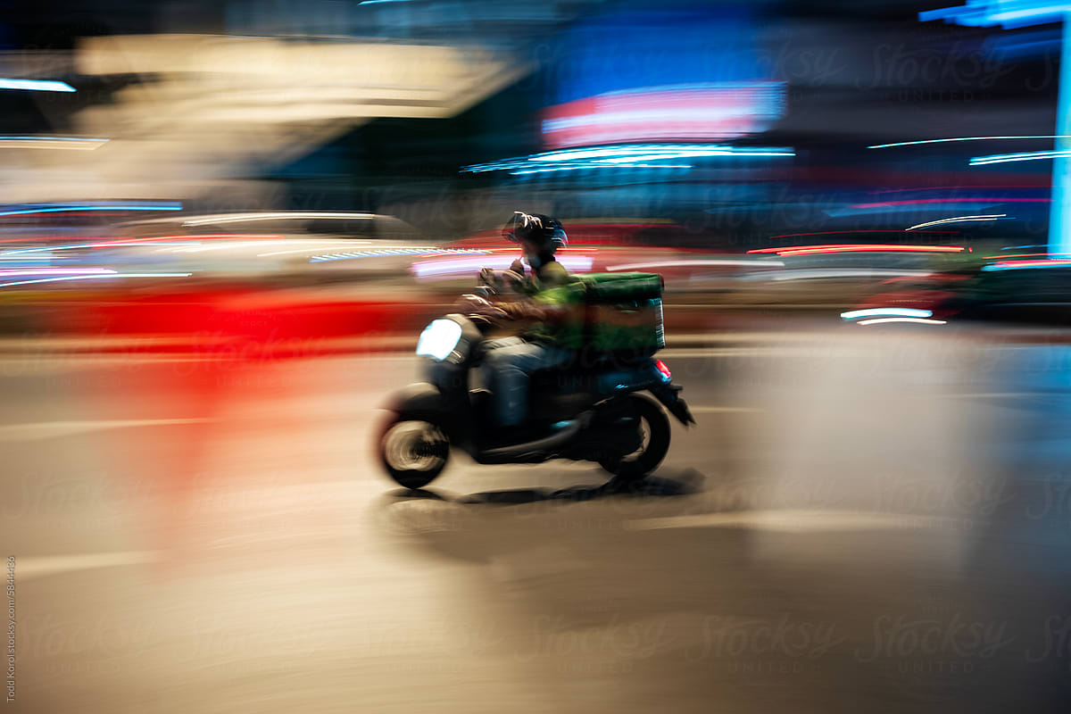 A scooter zooms through the night.