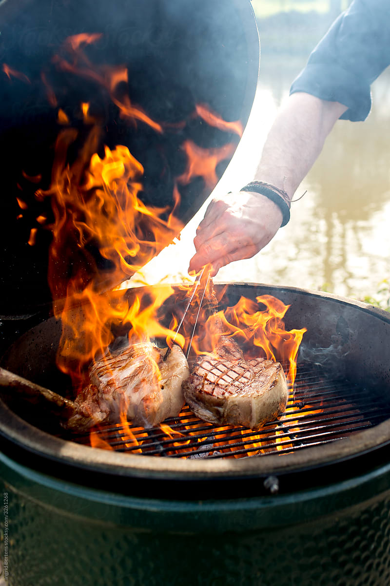 A man is roasting chops on a barbecue.