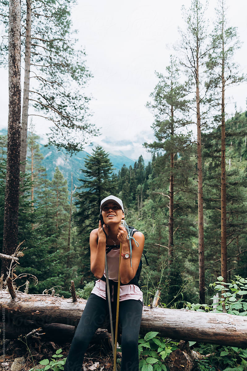 Happy female hiker resting in forest during trekking