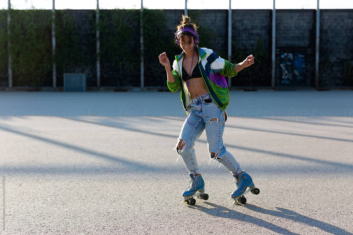 Roller-skater girl dancing cheerfully in sunlight