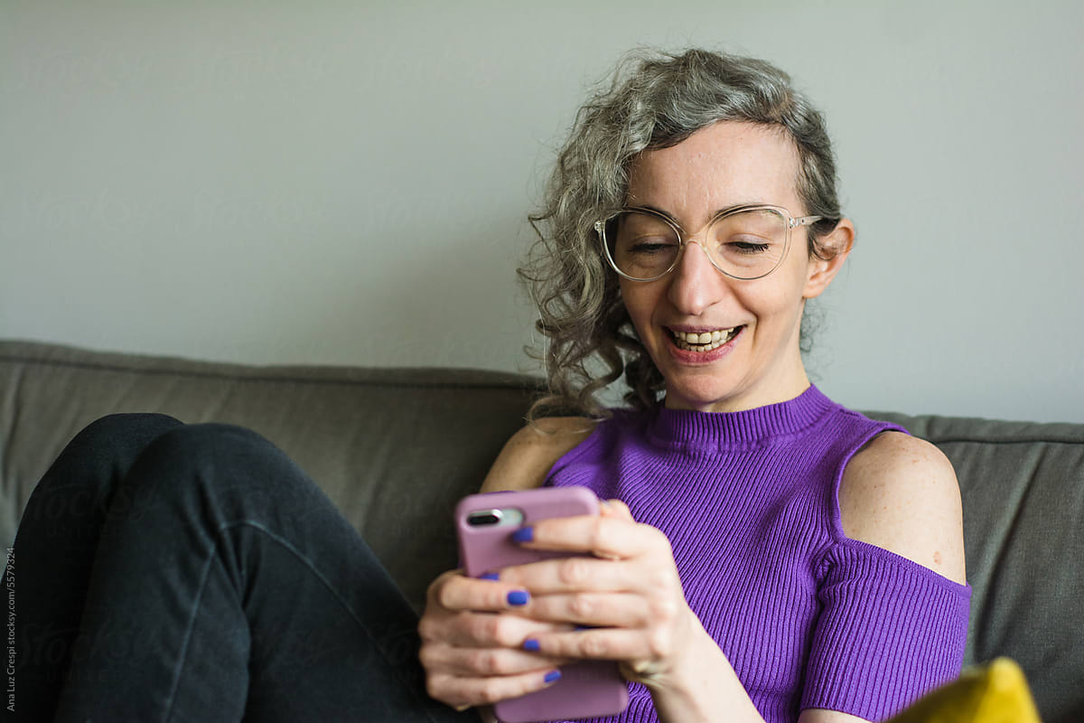 Woman smiling and texting with a friend
